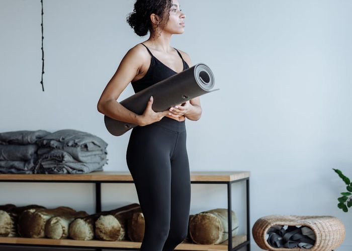 Person practicing a balancing yoga pose in a bright, modern studio.